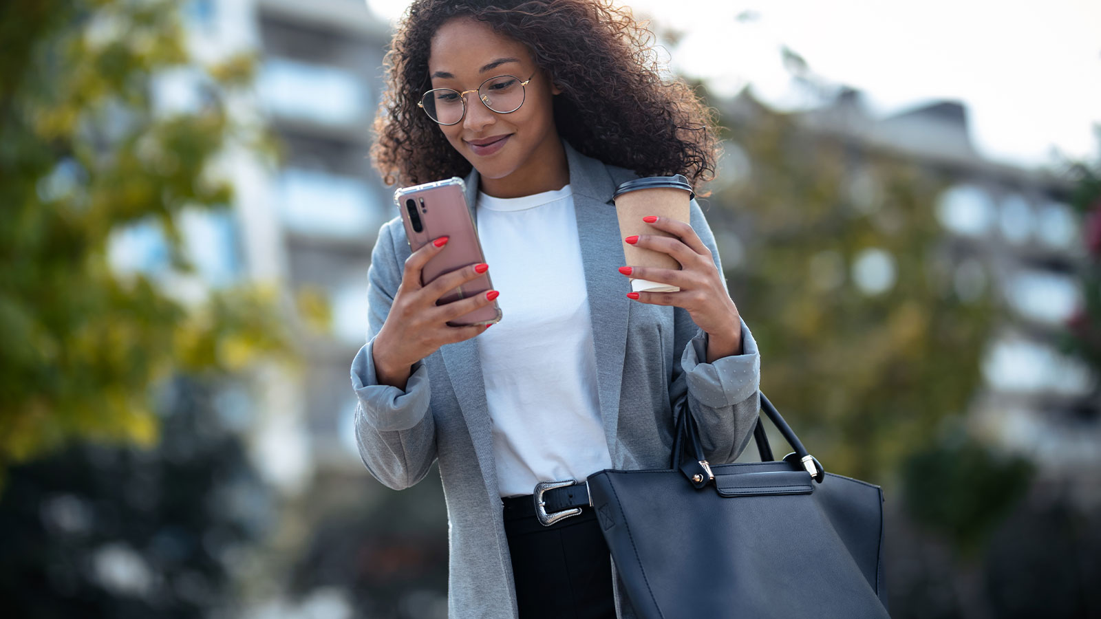 Woman checking her bank account on her smart phone while drinking coffee.