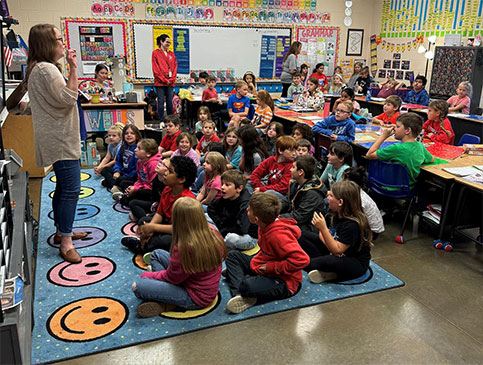 Armor Bank Team member reading to children.