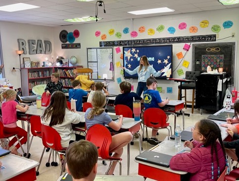 Armor Bank Team member reading to children in a school.