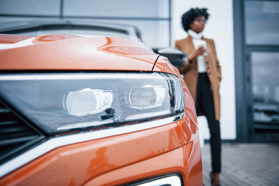 A young lady walking to her brand new car.